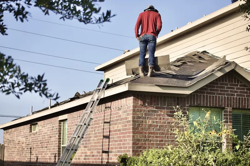 Professional roofer working on a residential roof in Denny Whitford